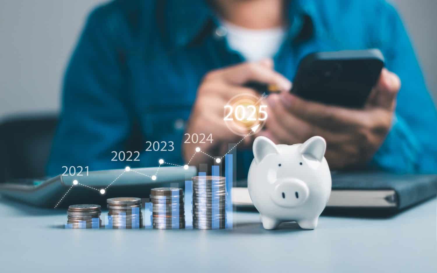 Closeup of stacked coin growth chart 2025. Man calculating financial planning. Concept of saving money, investment, emergency money, pension, insurance, interest or dividend.