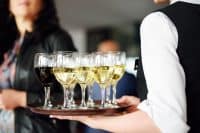 Waitress holding a dish of champagne and wine glasses at festive event, party or wedding reception