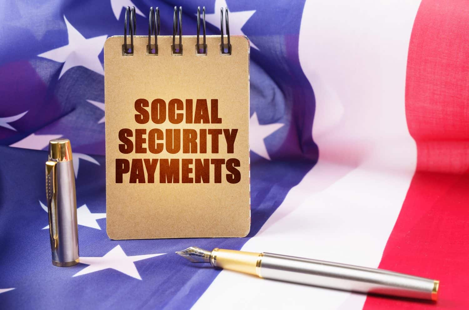 Business concept. Against the background of the American flag is a notepad with the inscription - social security payments