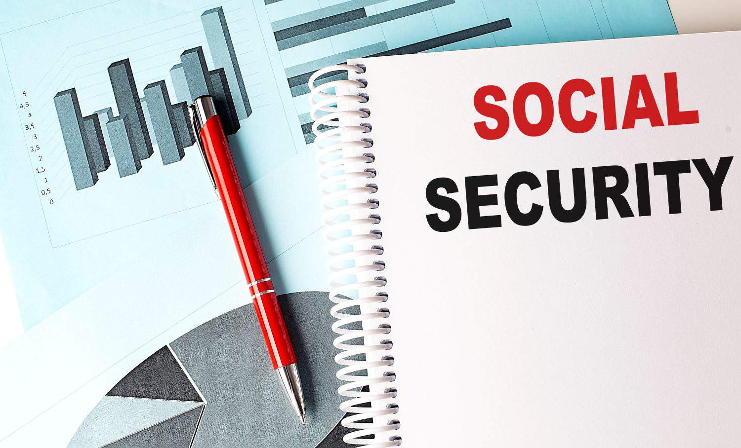 SOCIAL SECURITY text on notebook on a chart background .