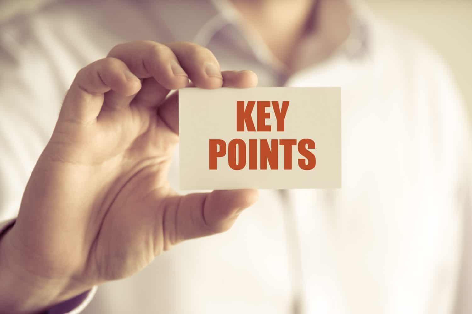 Closeup on businessman holding a card with text KEY POINTS, business concept image with soft focus background and vintage tone