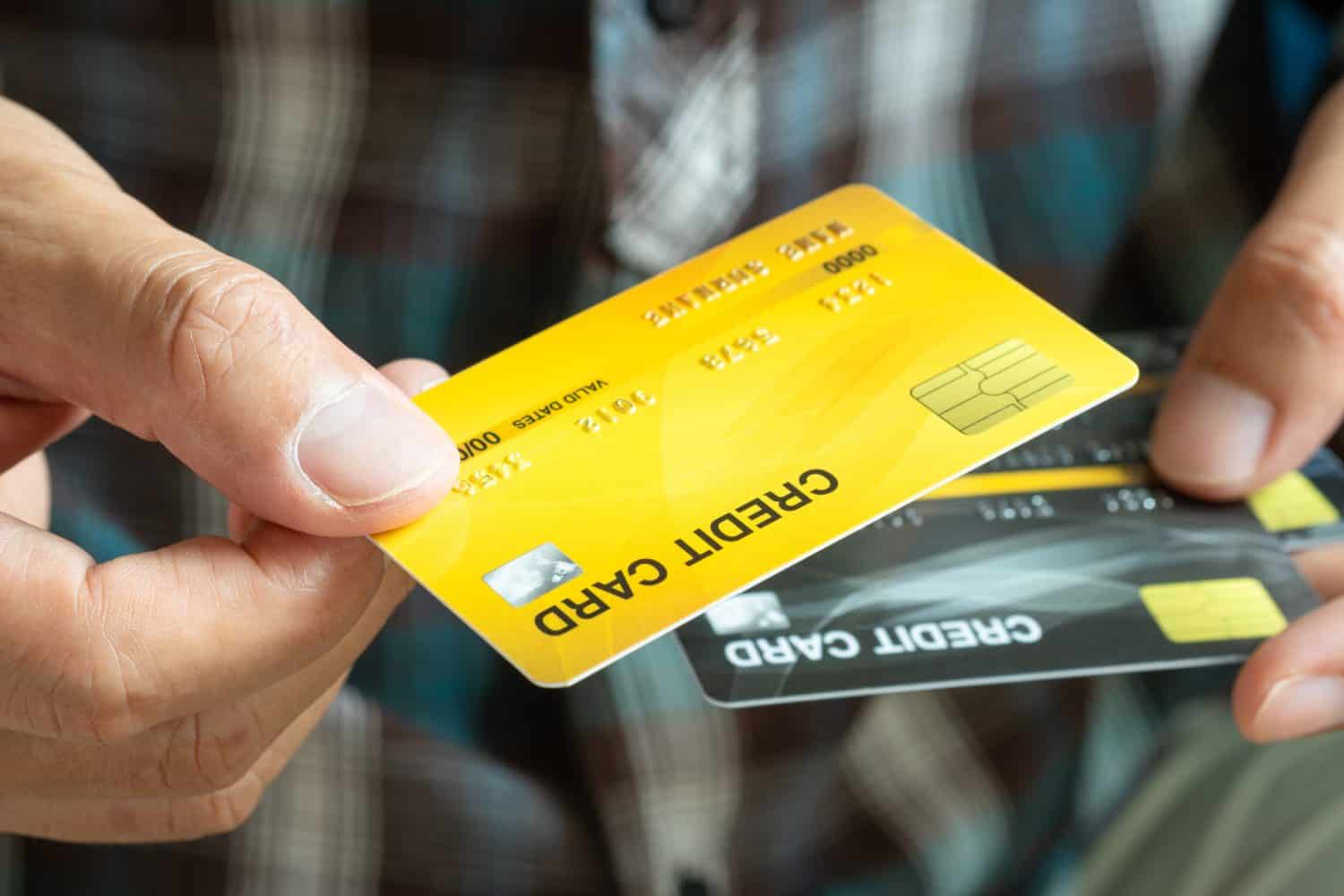 Man holding several credit cards and he is choosing a credit card to pay and spend Payment for goods via credit card. Finance and banking concept.