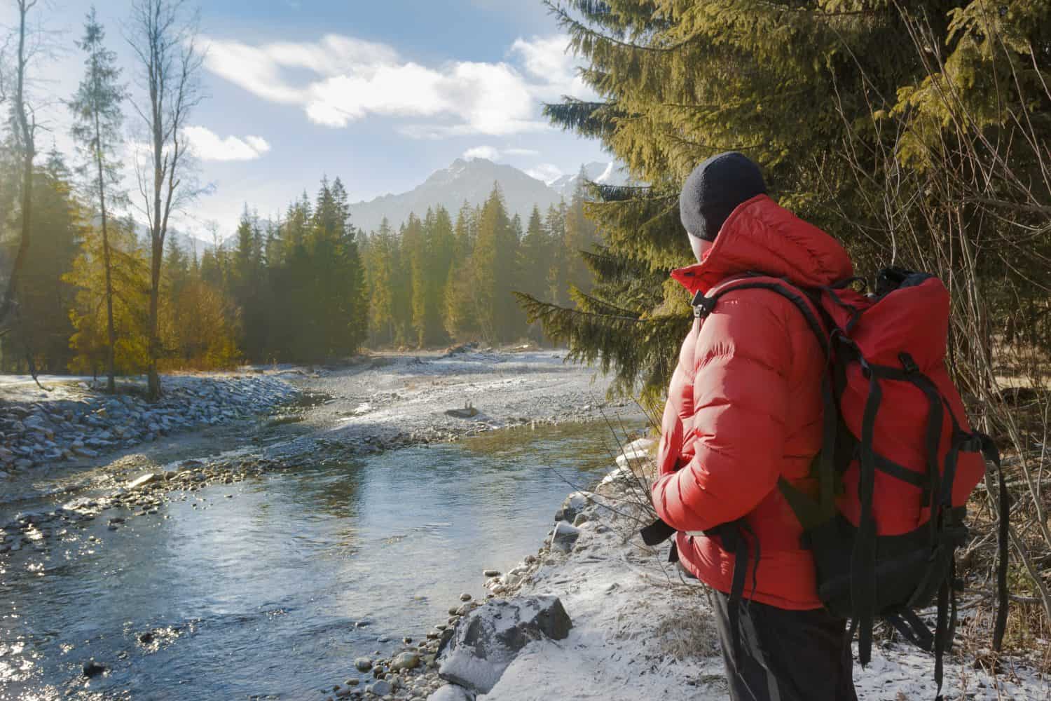 Backside of backpacker looking at winter rocky landscape view