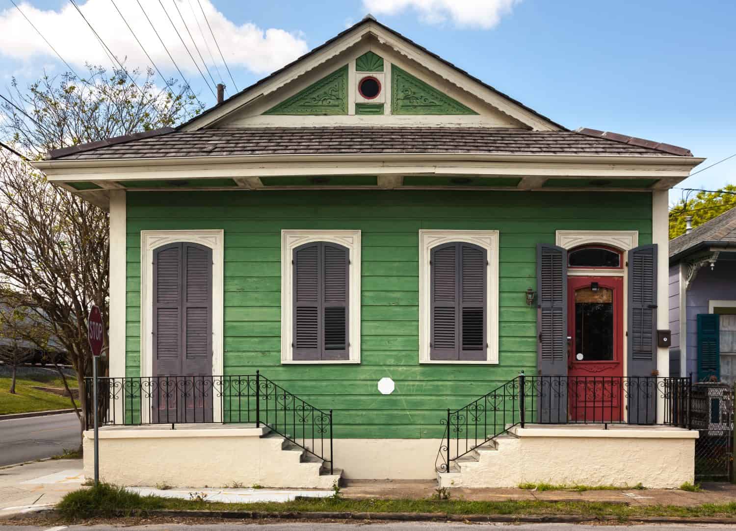 Faded green paint on a quaint duplex in the Bywater neighborhood of New Orleans, Louisiana.