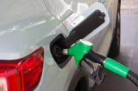 Close up of nozzle refueling azure blue car with gasoline