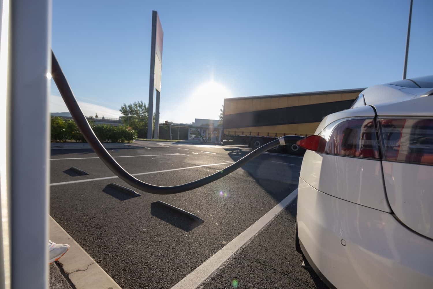 Charging an electric car. Modern electric car being charged on a fast charger on a motorway rest stop or gas station.