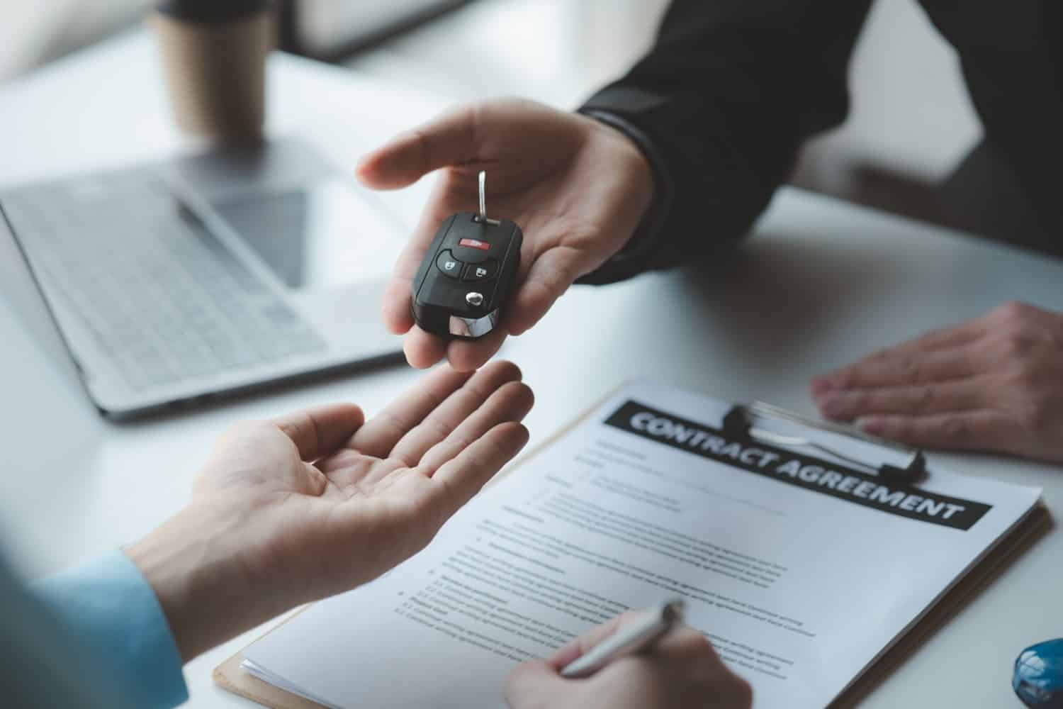 A car salesman is explaining the purchase details and details in the car purchase contract before signing acceptance of the terms, the car sales contract through an agent. Car trading concept.