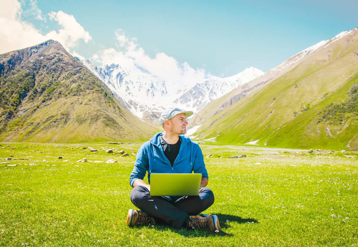 Freelancer digital nomad sit work online type on laptop with mountains scenic panorama.Location independent traveler blogging on travels. Ideas and work online in post pandemic world.Earth day concept