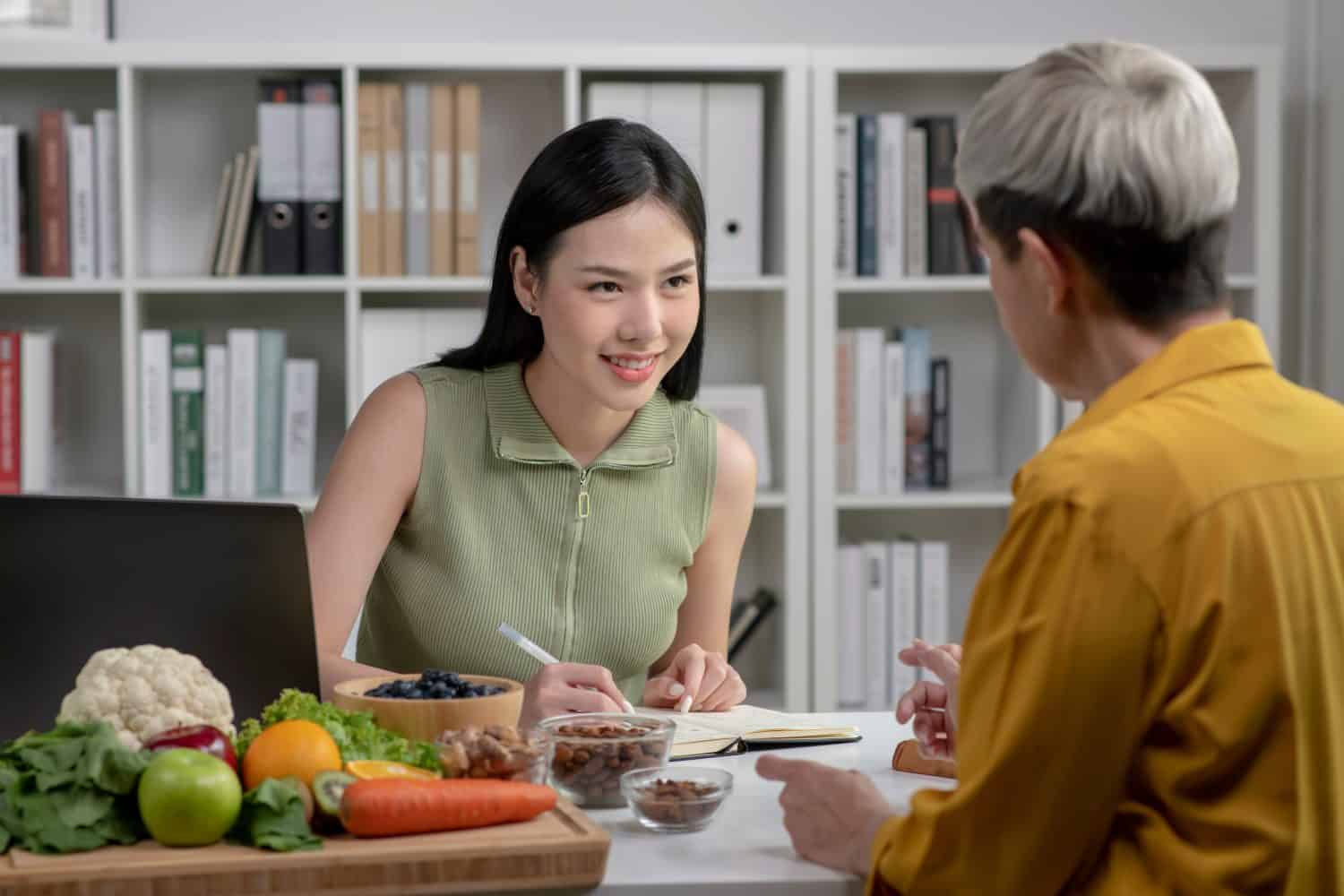 Nutritionist with woman client talking about meal plan and healthy products during a medical consultation in the office