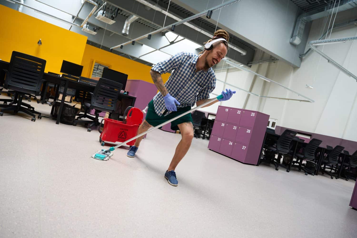 Informal janitor with headset in his ears imitates performance on stage