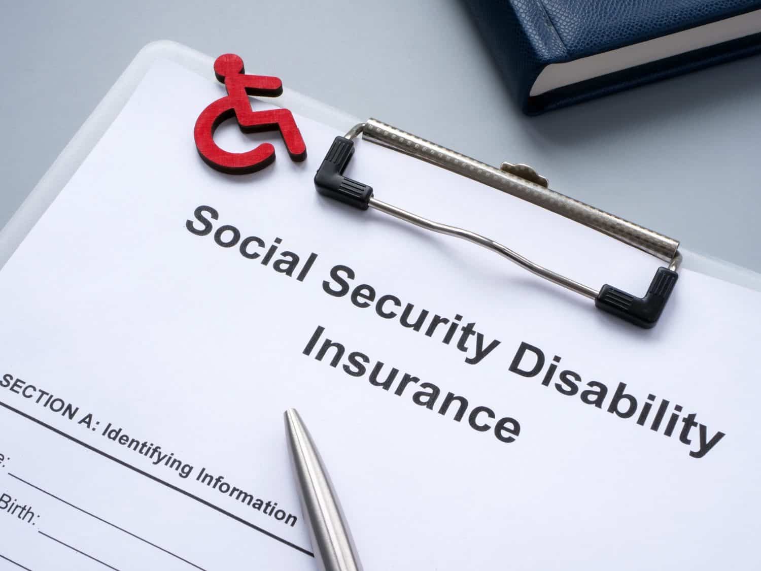 Clipboard with Social Security Disability Insurance SSDI policy.