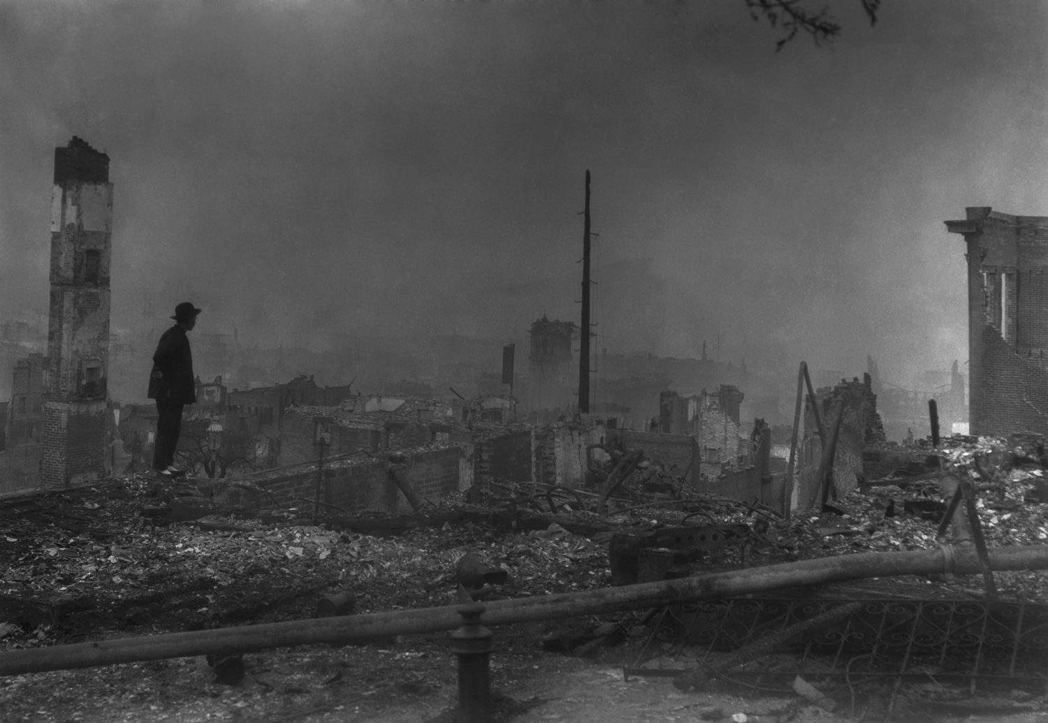 THE END OF OLD CHINATOWN, APRIL 23, 1906. By Arnold Genthe. Silhouette of a traditionally dressed Chinese-America against the ruins of San Francisco's Chinatown. April 1906 photo by Arnold Genthe.