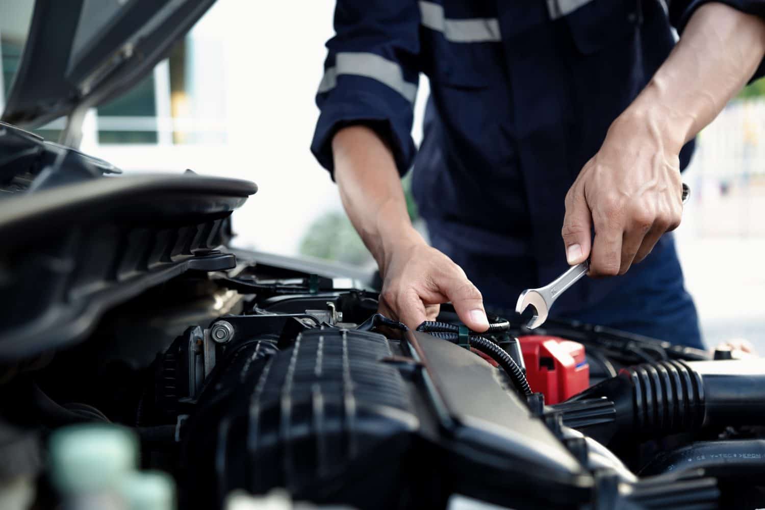 Mechanic are using the wrench to repair and maintenance auto engine at car repair shop,Car auto services and maintenance check concept.