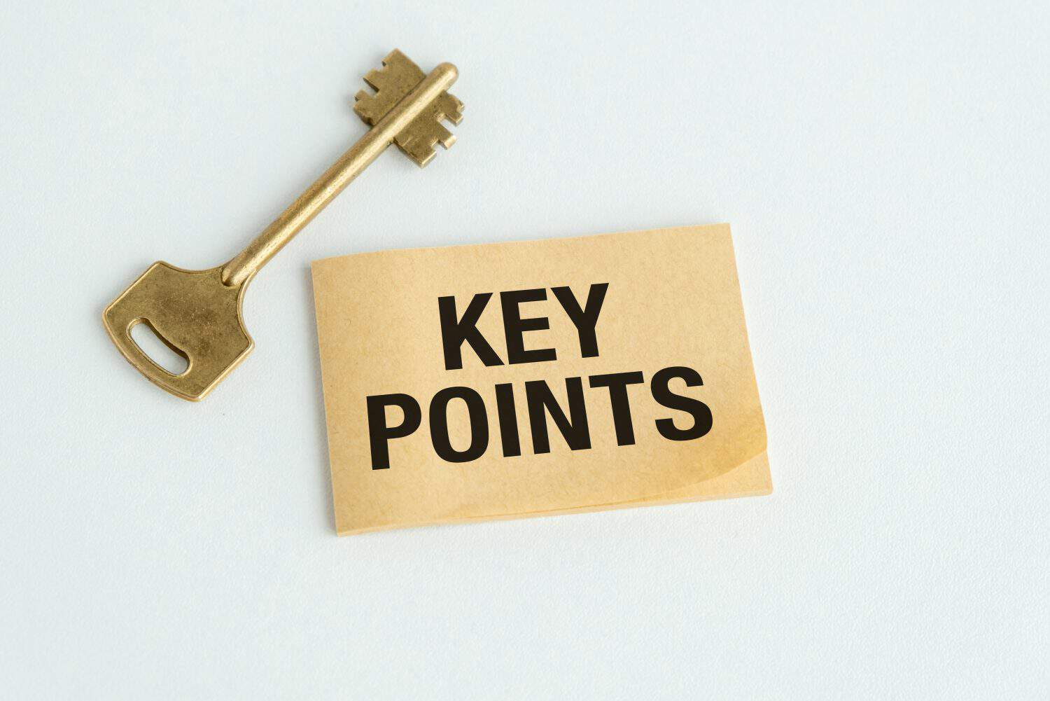 A key is on top of a piece of paper that says Key Points. Concept of organization and planning, as the key is often used to unlock doors and access information