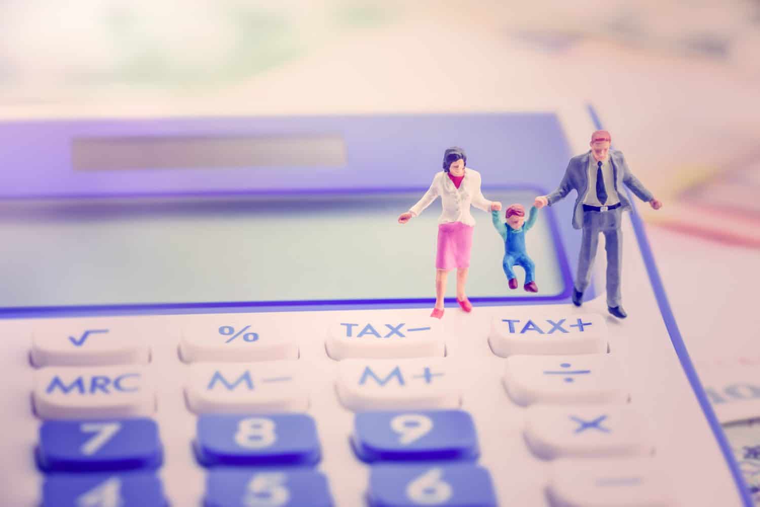 Family tax benefit or FTB / child care fee concept : Couple holds a child on a calculator, depicts a social security payment which is distributed to the parents or guardians of children or teenagers.