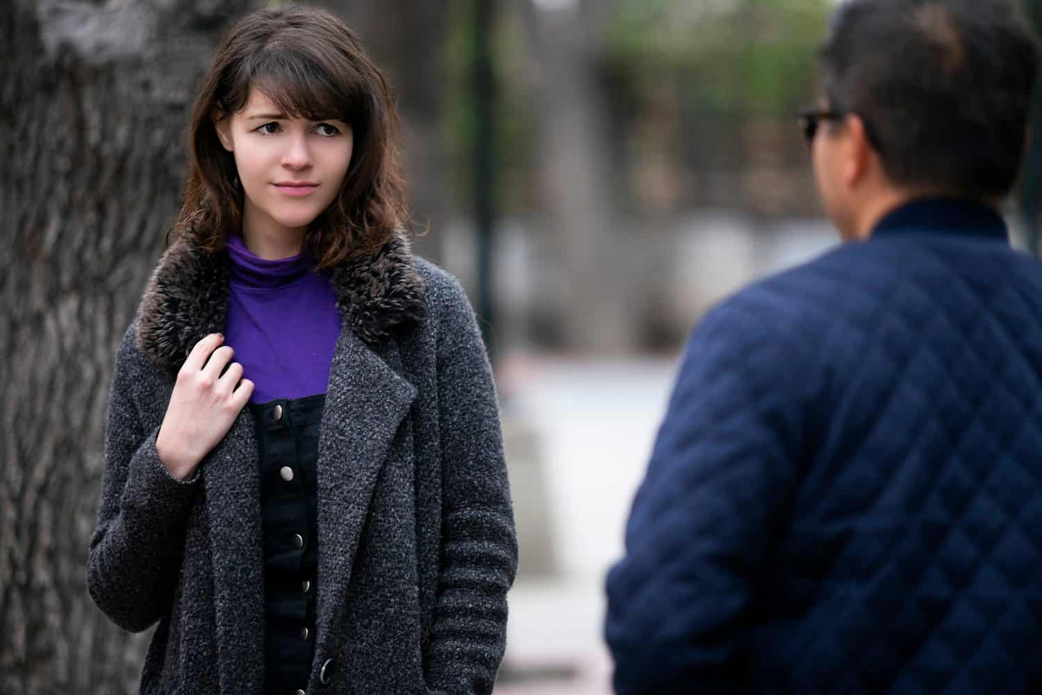 Woman walking outdoors in the city and looking snobby while running into an ex boyfriend or looking annoyed by an insulting stranger. It also depicts social anxiety.