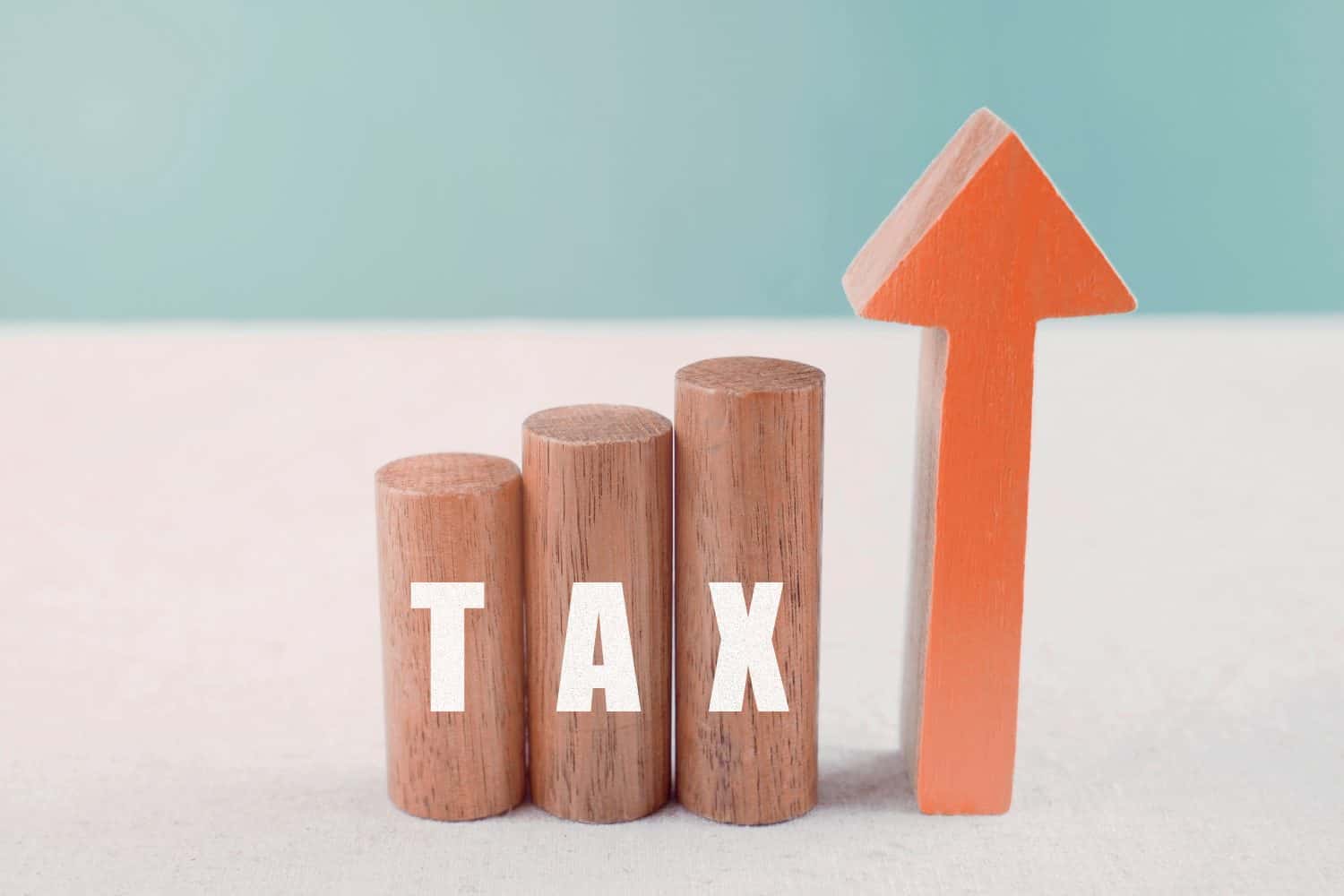 Wooden blocks with TAX word and red arrow increasing up, impacts of Covid-19 global economy financial crisis, raising tax concept