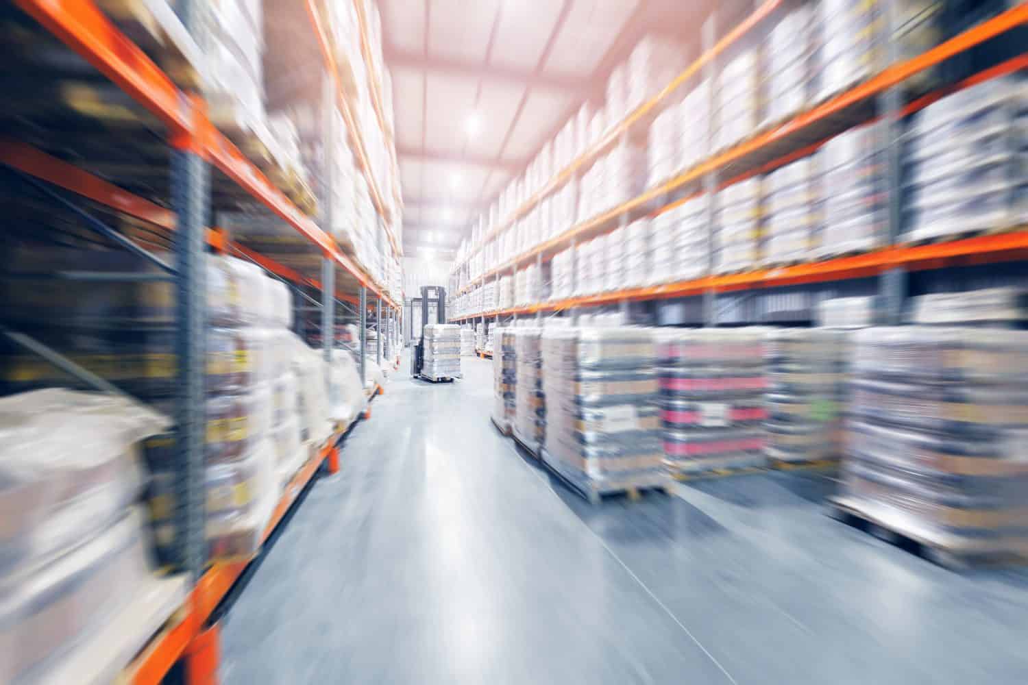 Forklift working in brewery warehouse stock industrial premises for storing kegs with beer. Concept logistics, transport. Motion blur effect, sunlight.