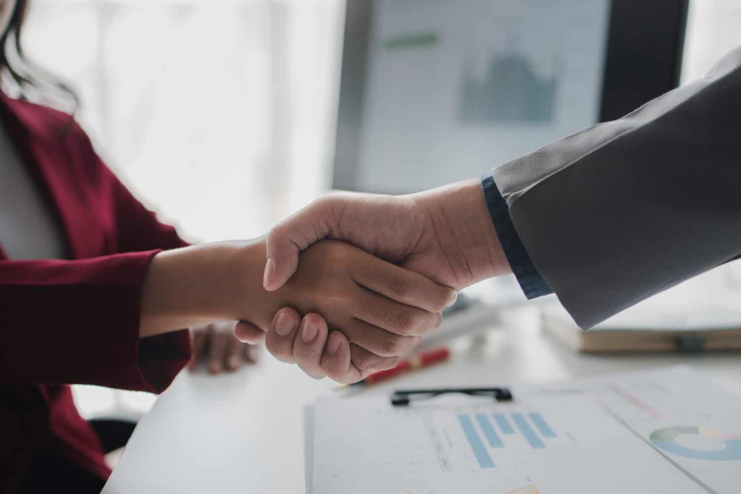 Two investors are shaking hands, business venture capitalists open a startup company together and shake hands after discussing a contract signing. Business investment concept.