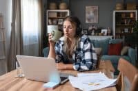 Side hustle money, second job concept. Young university student woman working freelance internet online job to pay student loan, saving money for rent, travel vacation Finance and economy video call