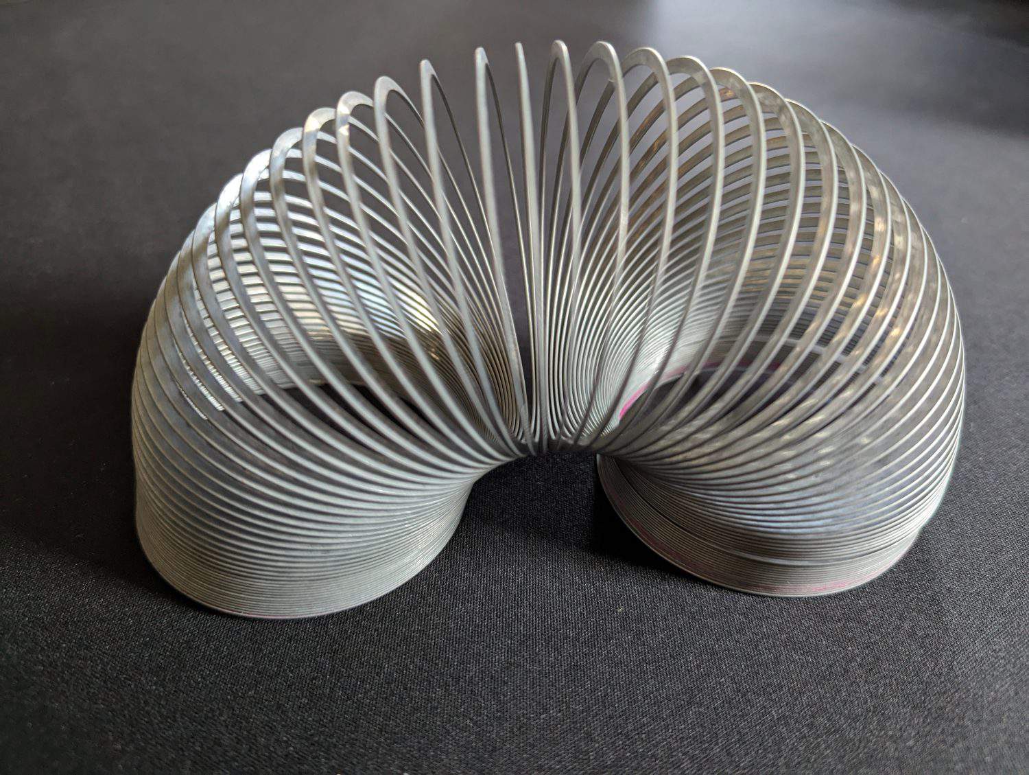 A closeup view of a metallic helical coil toy popularly known as a "Slinky".