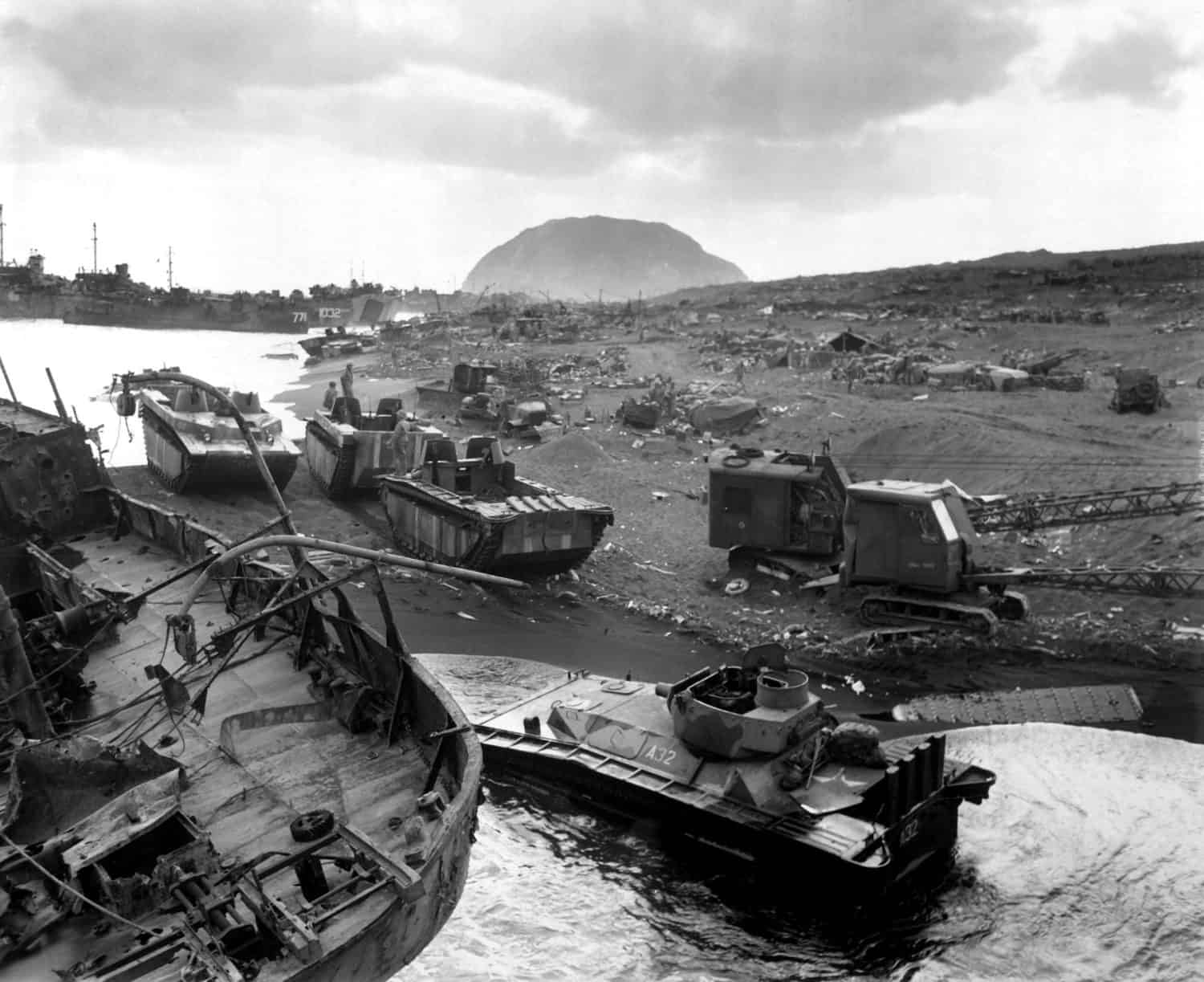 Vehicles of war knocked out on the black sands of the volcanic island of Iwo Jima. They were smashed by Japanese mortar and shellfire. Ca. March 1945.