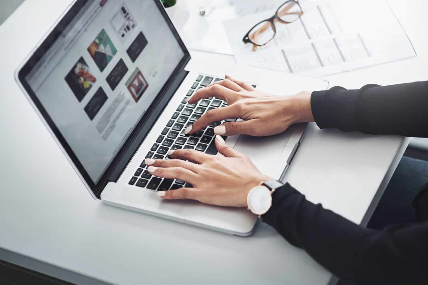 Hands, computer and typing at desk for remote work, research and magazine editing. Woman, journalist and laptop screen in home office for article, news update and language translation for information