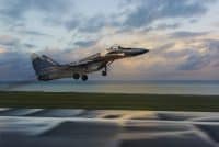 Fighter jet taking off at sunset