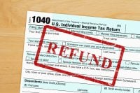 Refund message with US federal 1040 tax return form on a wood desk
