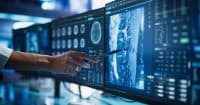 Modern Medical Research Center: Anonymous Doctor Pointing At Desktop Computer Monitor With Software Visualizing Human Brain Based On MRI Scan. Neurologist Looking For Impacted Areas By Brain Damage.