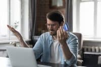 Man sit at desk with laptop use online banking service, faced with blocked credit card, financial problem, check balance feels irritated. Internet fraud, unsuccessful pay, money theft, funds overspend