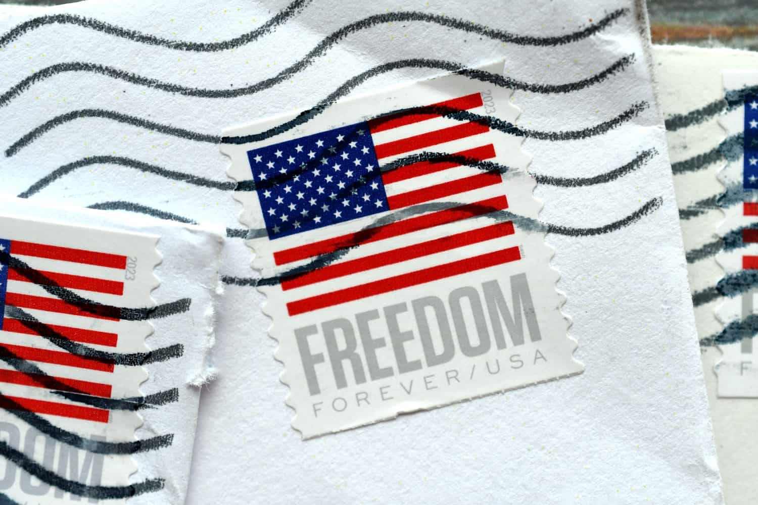 Closeup of US postage Forever stamps with American flag with postmark