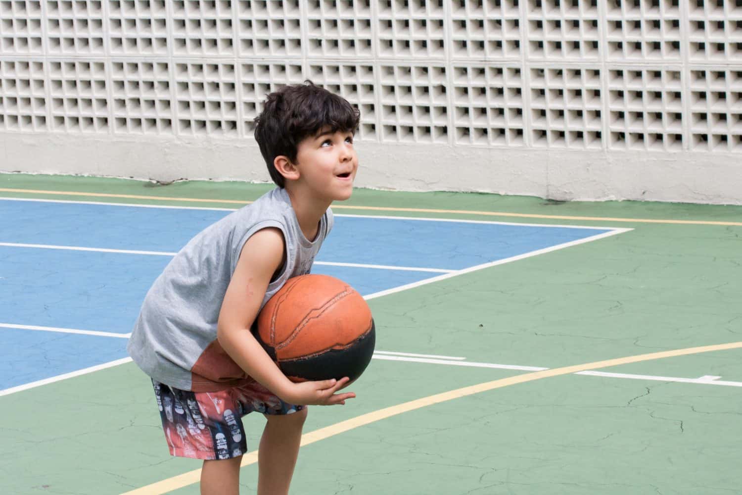 Boy ready to throw basket ball on court