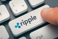 finger pressing computer key with ripple coin logo. crypto mining concept