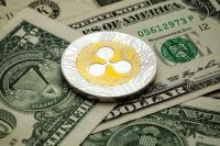 Ripple Cryptocurrency coin on a pile of US dollars, cash money and cryptocurrency concept