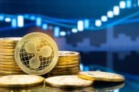 Ripple (XRP) and cryptocurrency investing concept - Physical metal Ripple coins with global trading exchange market price chart in the background.