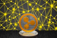Ripple XRP on cryptocurrency coin with black and gold blockchain network concept in background. The cryptocurrency coin is golden and in focus. Blockchain is a public decentralized distributed ledger