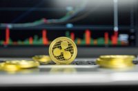 Golden Ripple coin with gold coins lying around on a black keyboard of silver laptop and diagram chart graph on a screen as a background. Mining of ripples online bussiness. Trading.