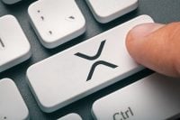 Cryptocurrency trading concept: Male hand pressing computer key with Ripple | Xrp logo. Cryptocurrency mining, trading, market concept.