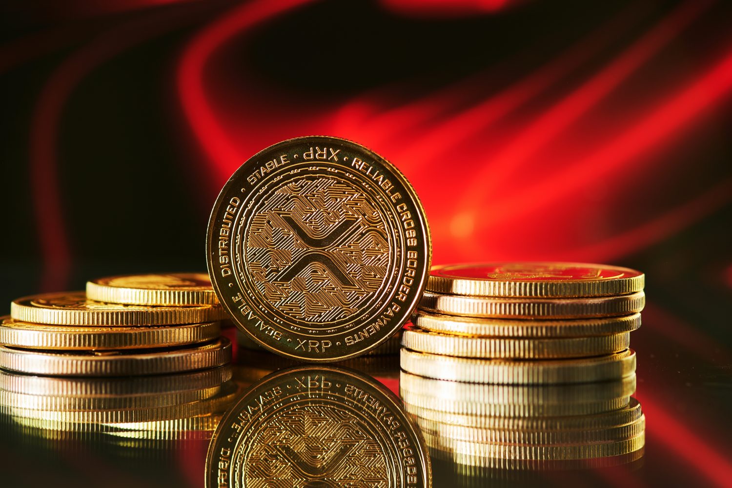 Close up of golden Ripple XRP cryptocurrency with red abstract background