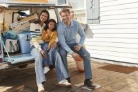 Young family sitting on tailgate of vehicle
