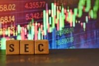 A close up picture of letters SEC in front of stock market chart. Stock market regulator in USA is called SEC. It makes laws related to Finance in USA.