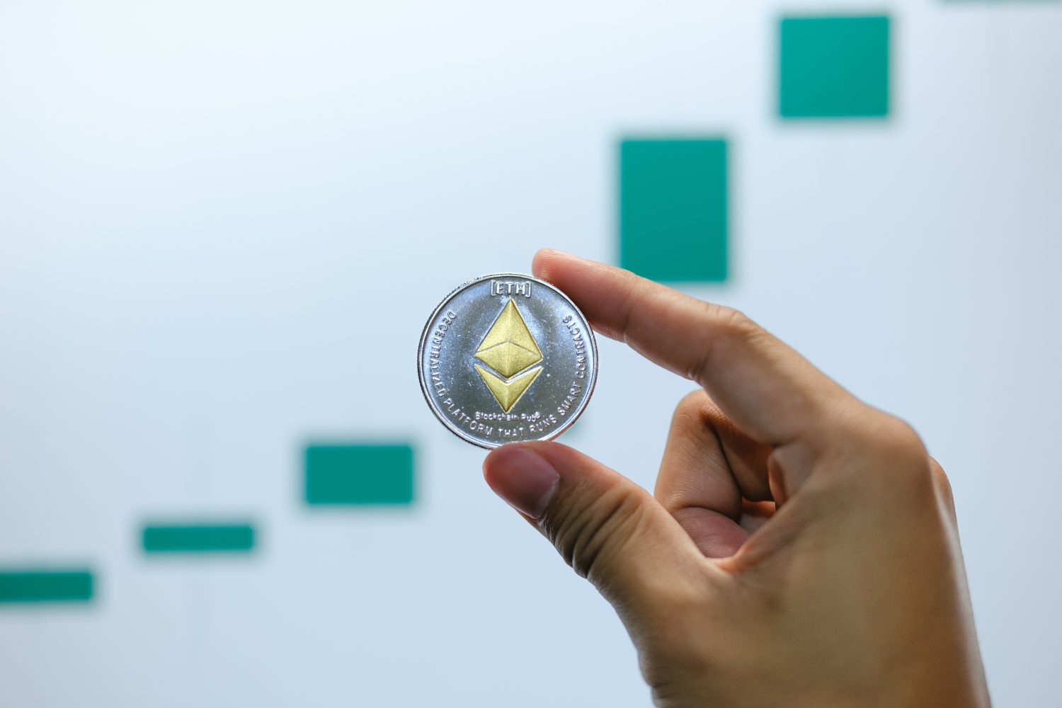 Ethereum physical coin symbol on a laptop with uptrend price graph background, future concept financial currency, cryptocurrency sign.