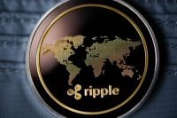 Golden ripple coin. Crypto XRP Coin on dark wood background and wallet. Close-up, macro shot.New Virtual Money