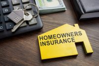 Homeowners insurance inscription on the wooden home.