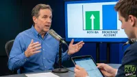 A man in a blue shirt speaks into a microphone, gesturing with both hands, while another man in a suit looks intently at a tablet screen. Behind them, a large display shows a bar chart comparing 'ROTH IRA' (green bar with upward arrow) and 'BROKERAGE ACCOUNT' (taller blue bar). A '24/7 WALL ST' logo is visible in the bottom right corner.