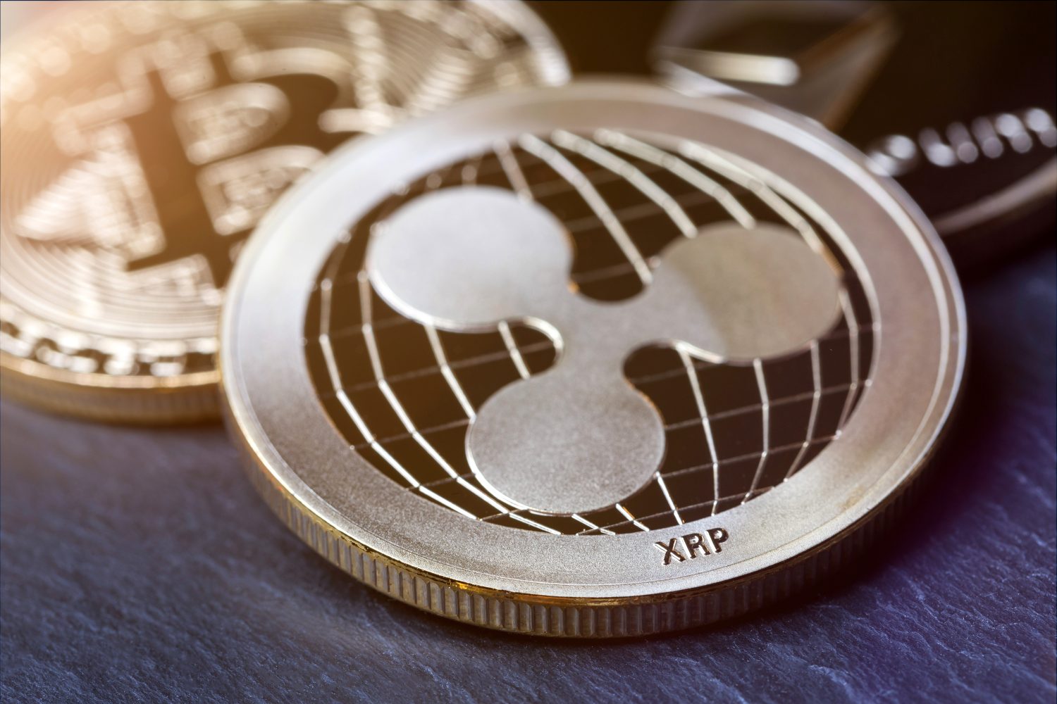 ripple coin and other crypto coins on a slate plate