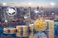 Ripple XRP and cryptocurrency investing concept - Physical Ripple coins with city background and exchange market trading price chart. Blockchain and financial technology.