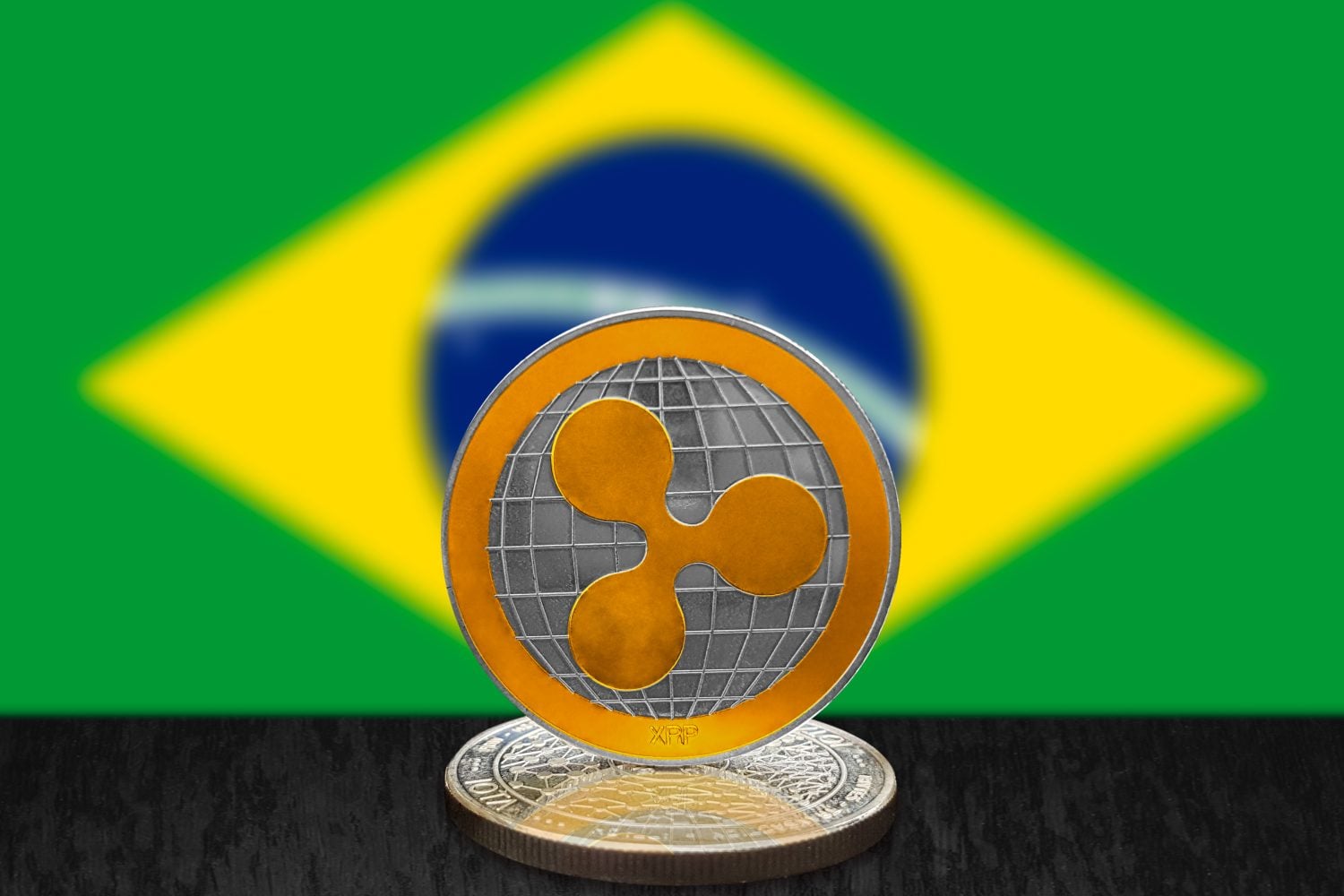 Ripple XRP on cryptocurrency coin with Brazilian flag in background. The cryptocurrency coin is golden and in focus. This is a Brazil Ripple concept.