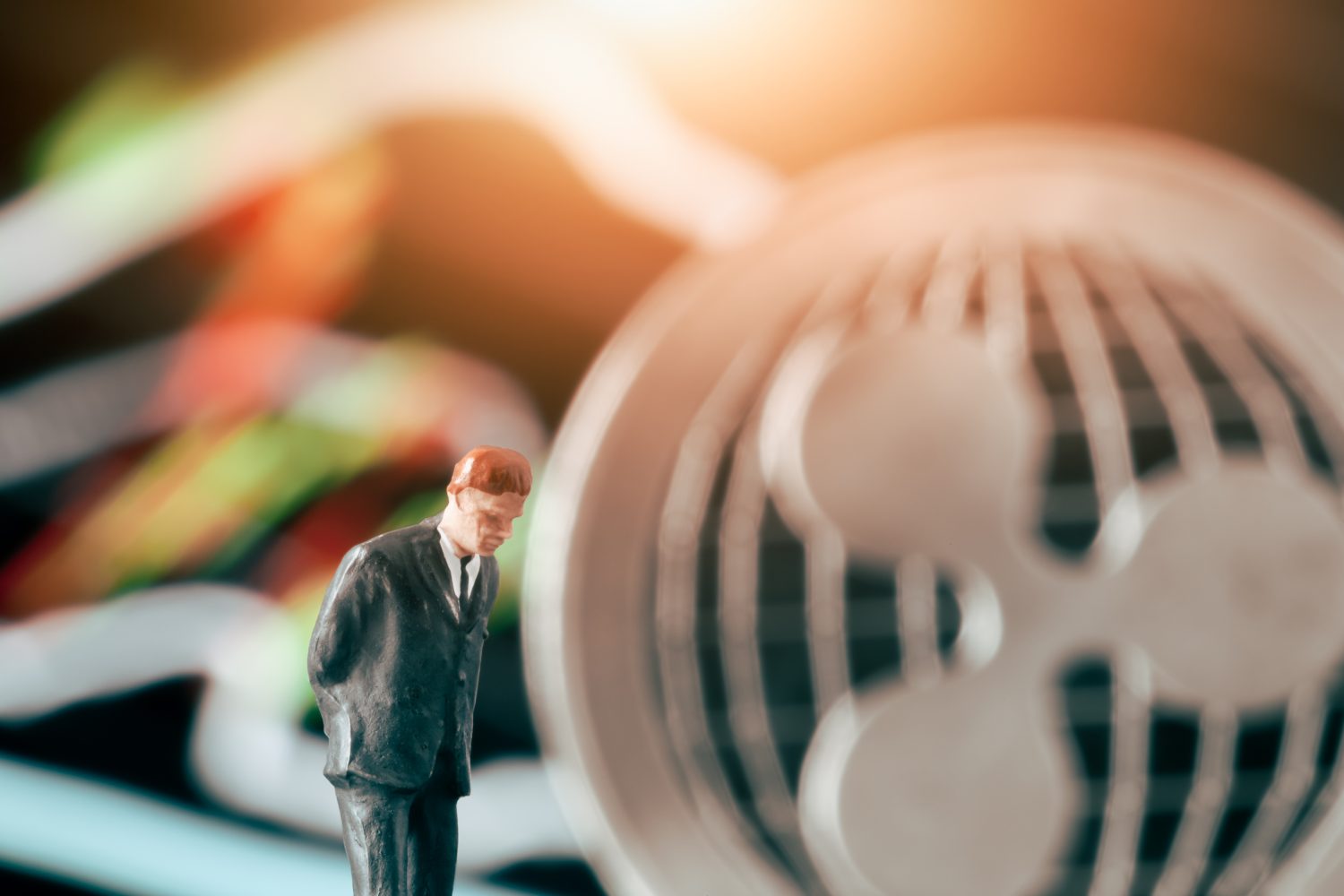 Cryptocurrency concept with thinking businessman: Businesman figurine with hands behind back, deciding to make a decision in front of market chart and ripple.